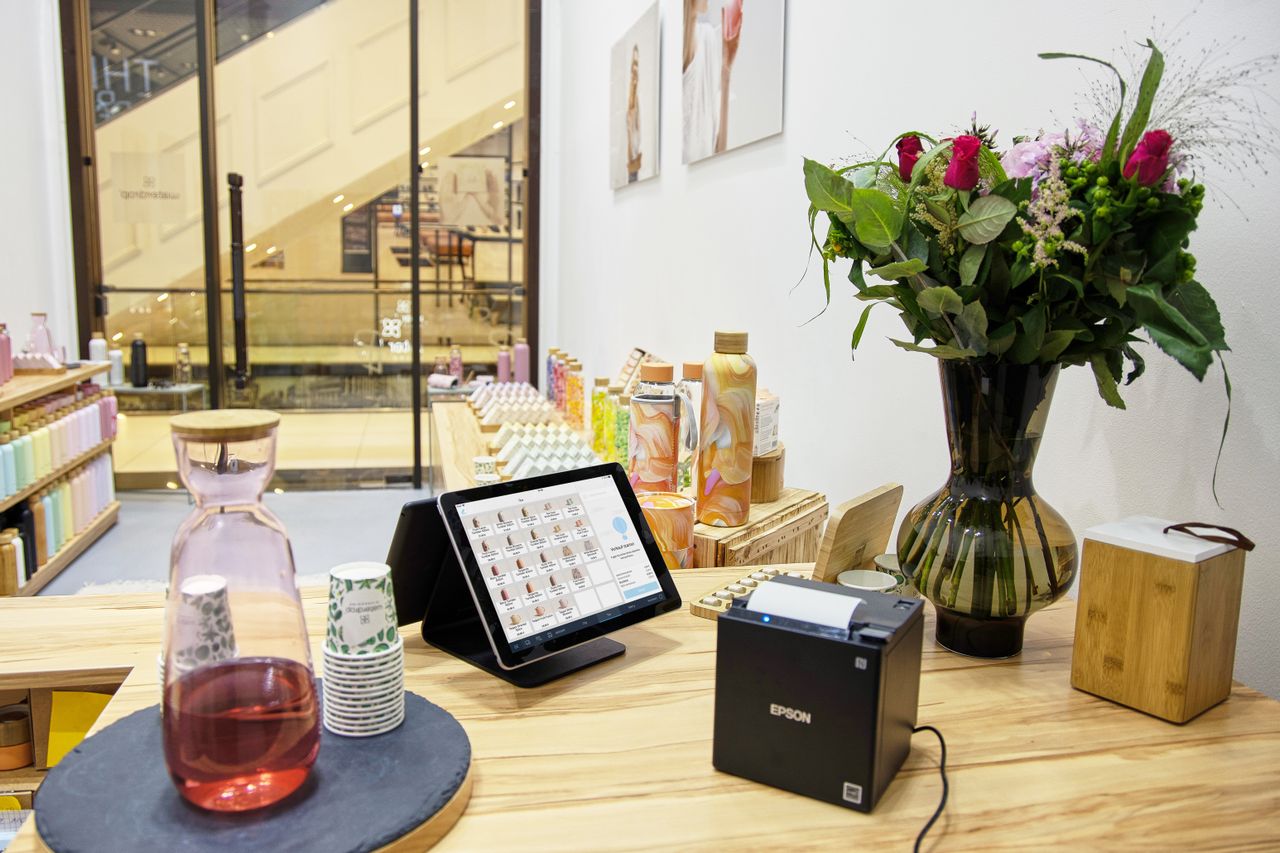 The Art of Drawing Readers In: Your attractive post title goes here A stylish store checkout counter featuring a floral bouquet and digital payment system.
